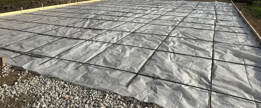 Vapor barrier and rebar laid out on gravel before a concrete pour