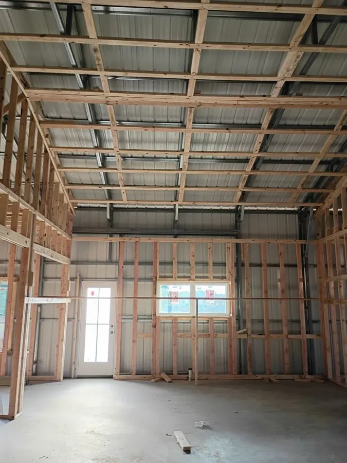 Steel building interior with wood stud framing on a finished slab